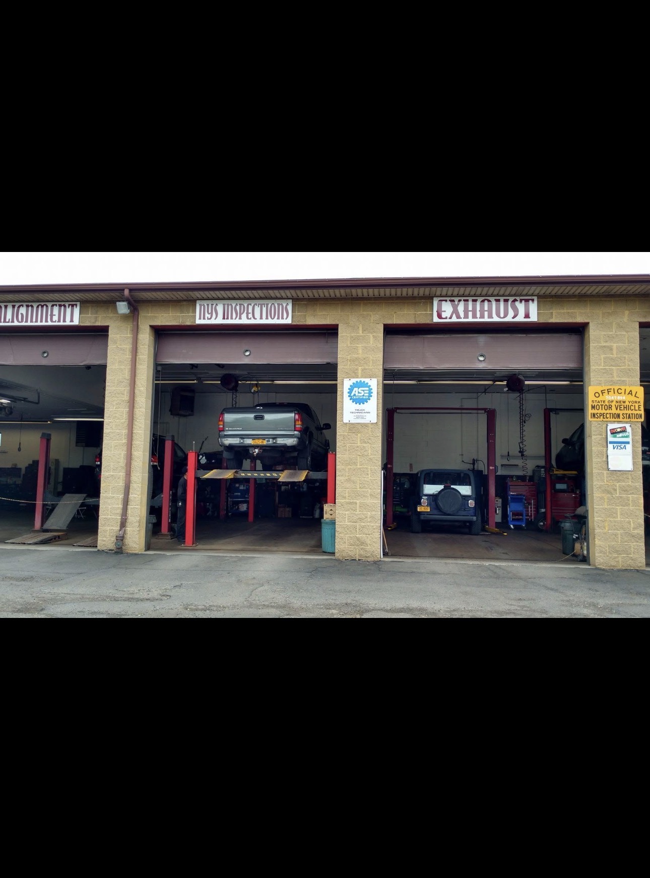 Sam's Auto by CUBI garage front with alignment, NYS inspections and exhaust bays open